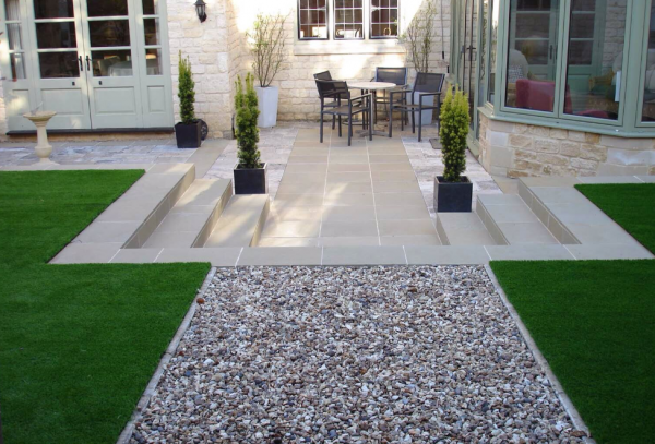 Taman dengan rumput sintetis dan batu hias